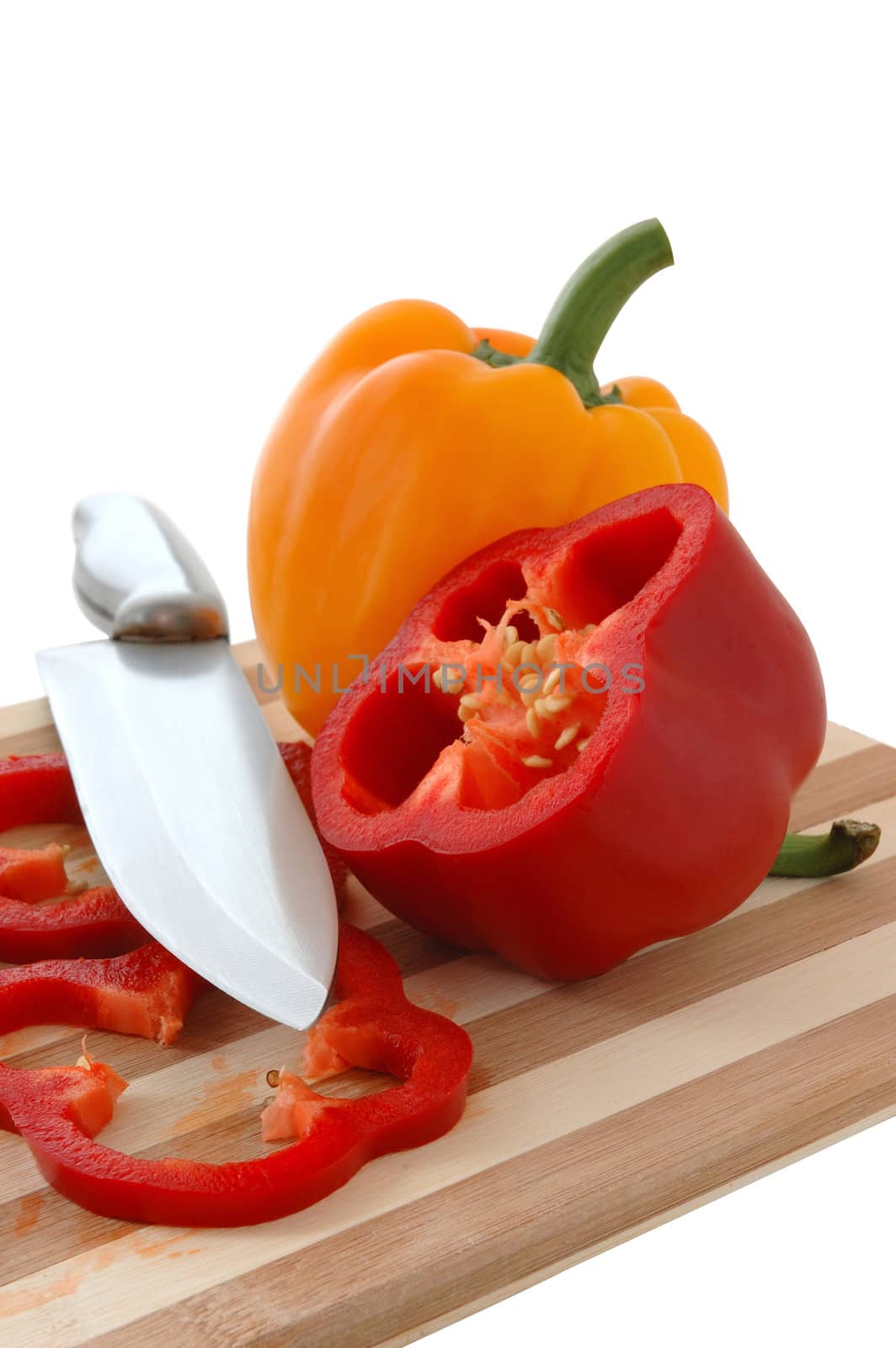 Red and yellow paprika on bamboo cutting board.