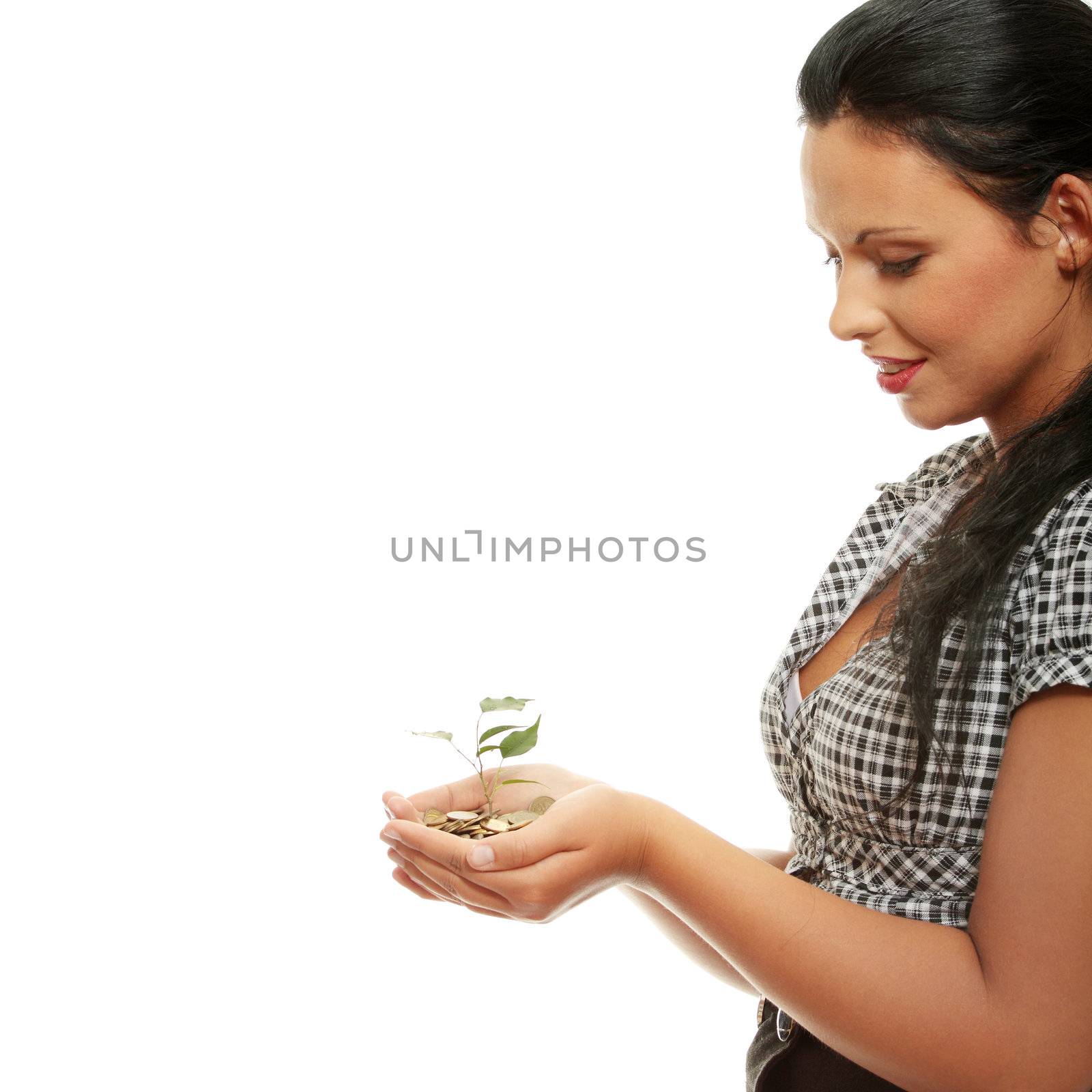 Young business woman holding small tree growing from coins. Isolated on white background