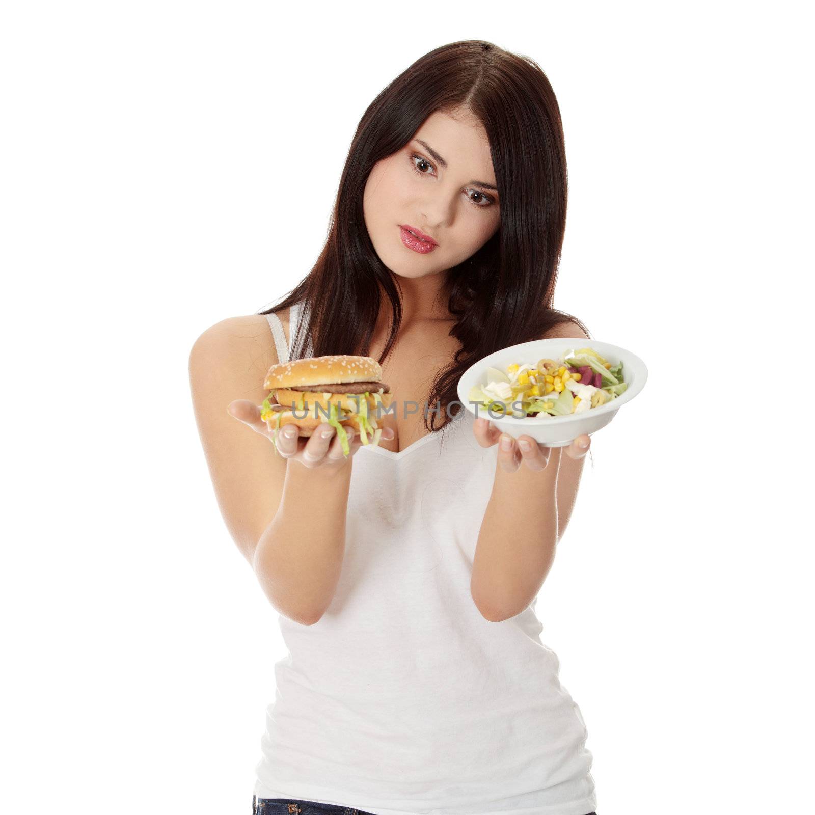 Beautiful caucasian woman thinking whot to eat: hamburger or salat. Isolated on white