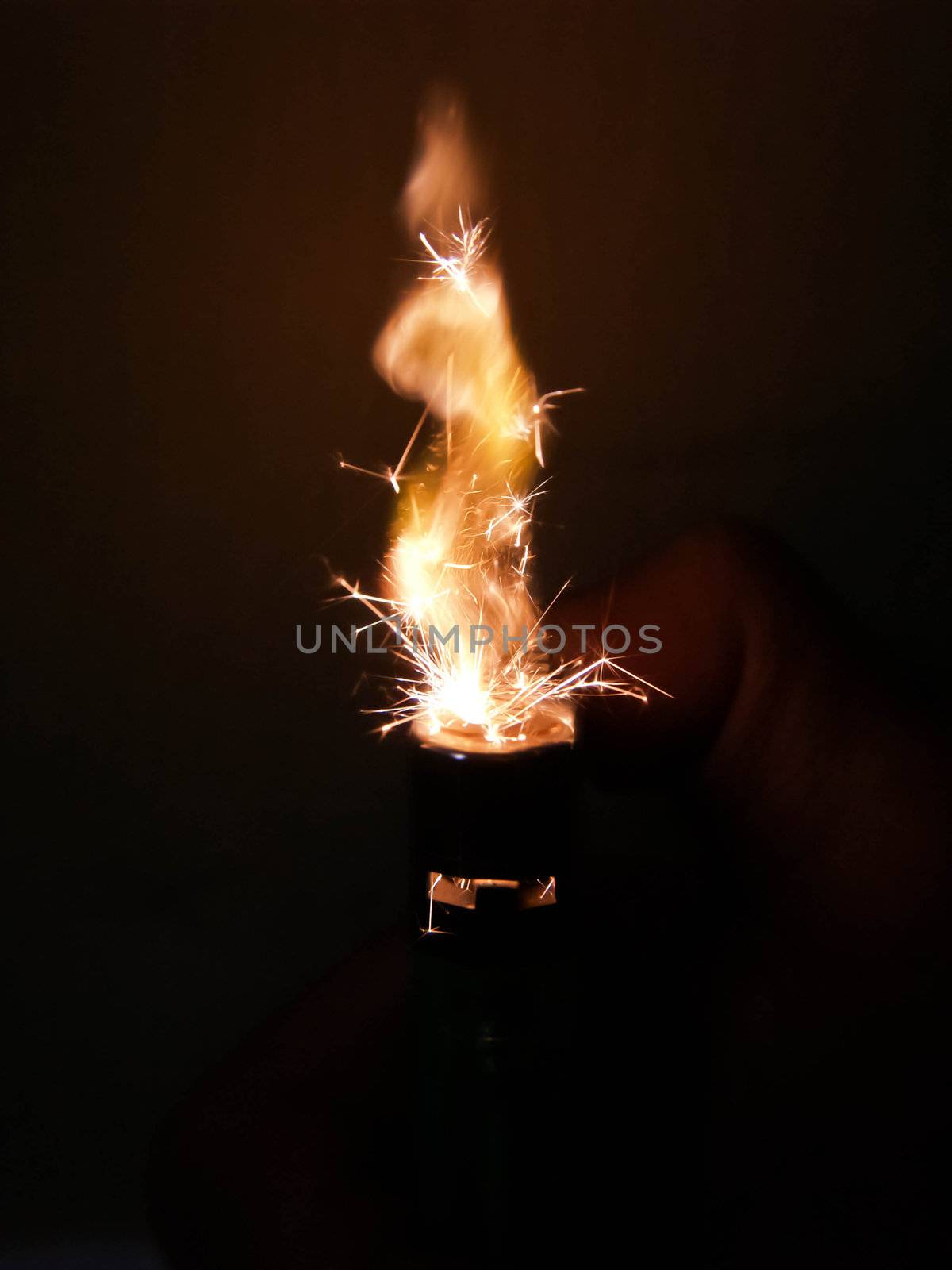 hand holding a blazing match lighting just as it burst into flame.