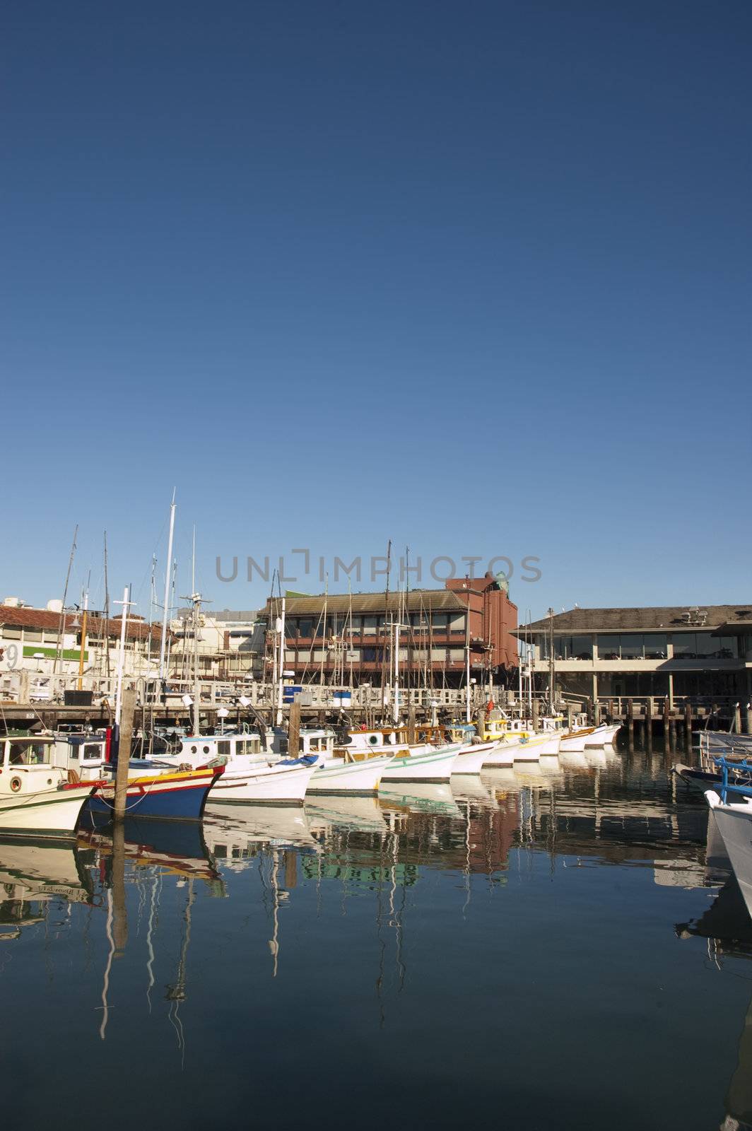 Fisherman's Wharf in San Francisco with the fleet in harbor and reflected in the water