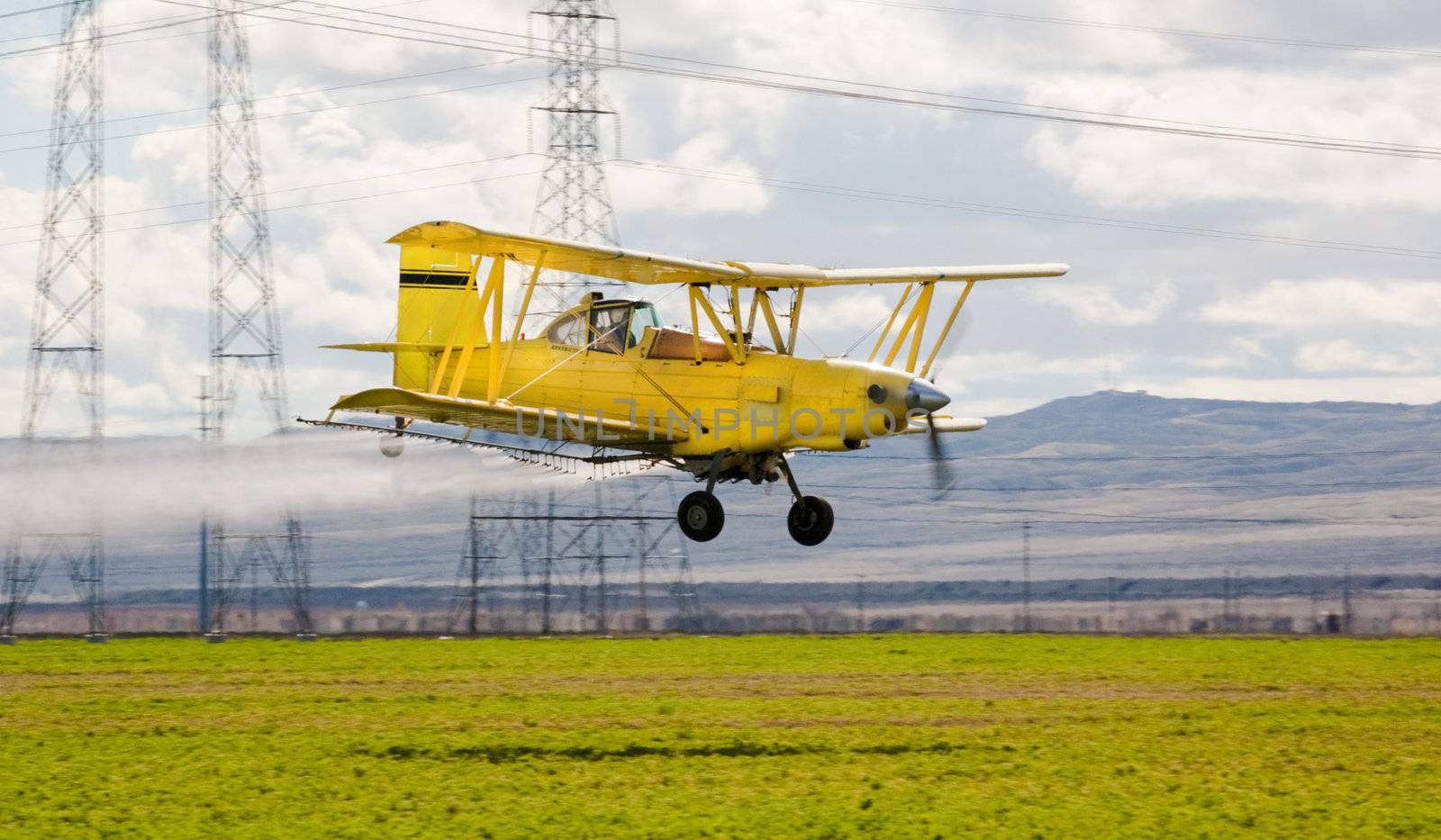 crop duster spraying insecticide on crops in central California