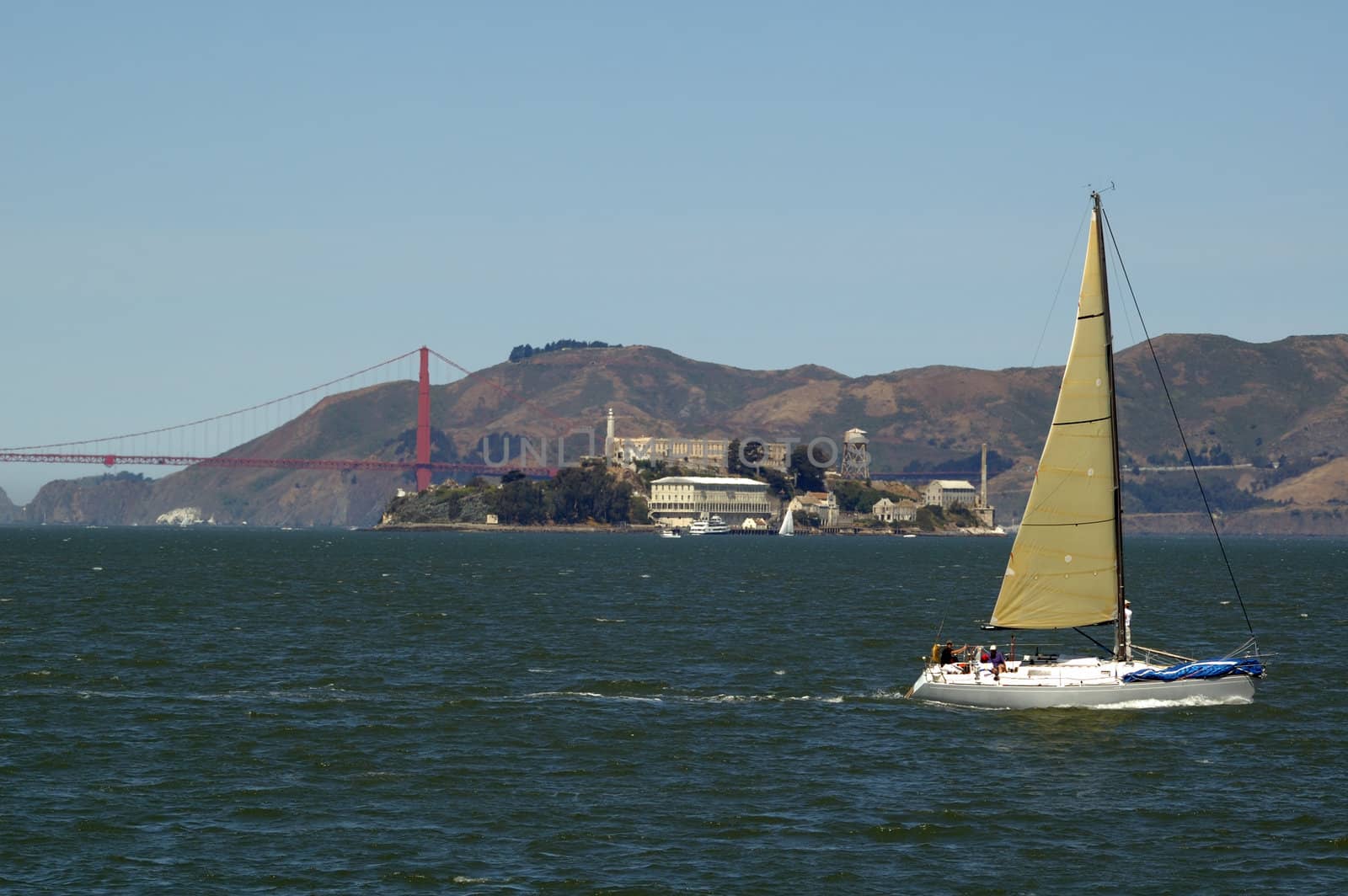 Yatch sailing on San Francisco bay with the Golden Gate bridge and Alcatraz in the distance with Marin Headlands behind