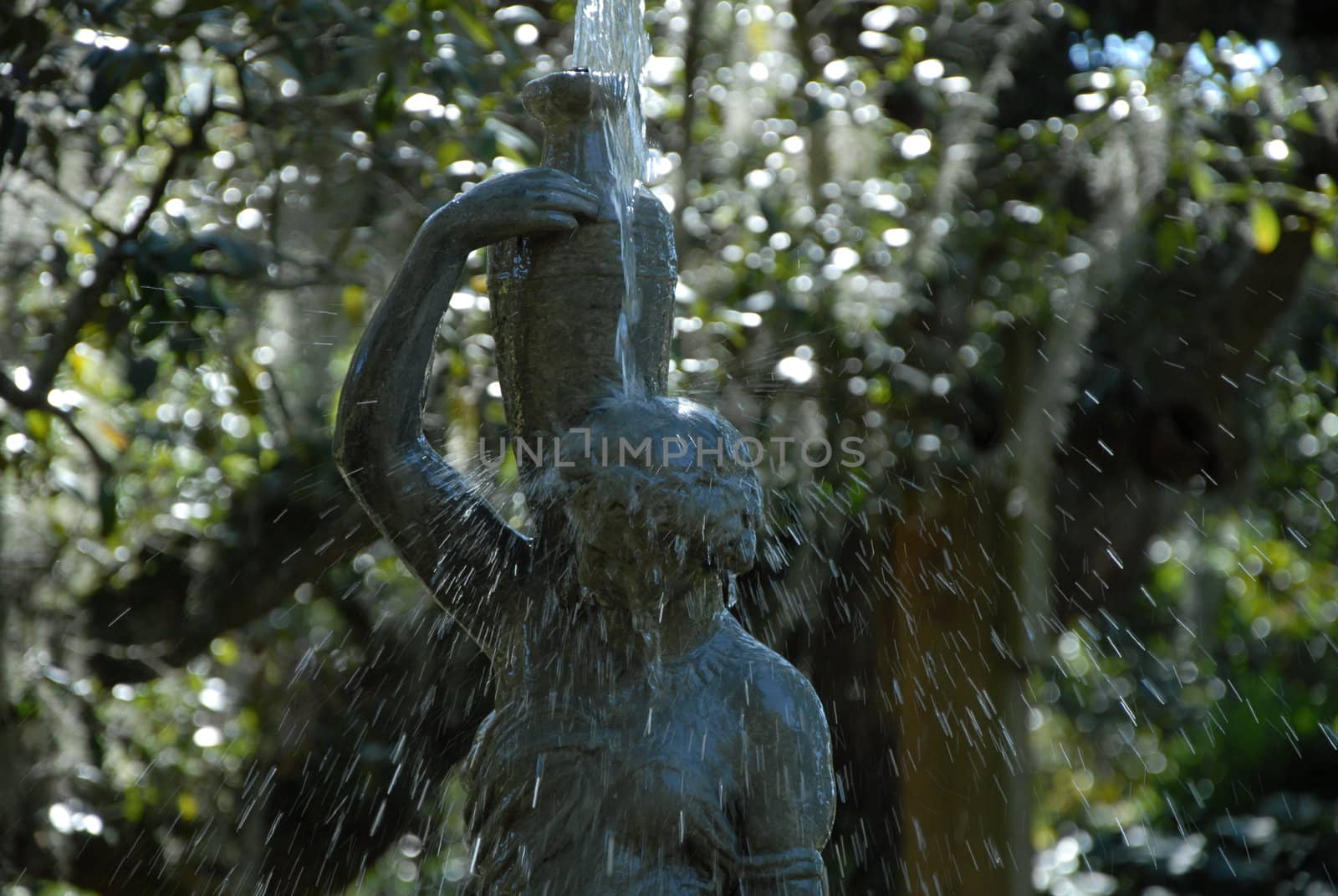 Water flowing over a statue in a European style park