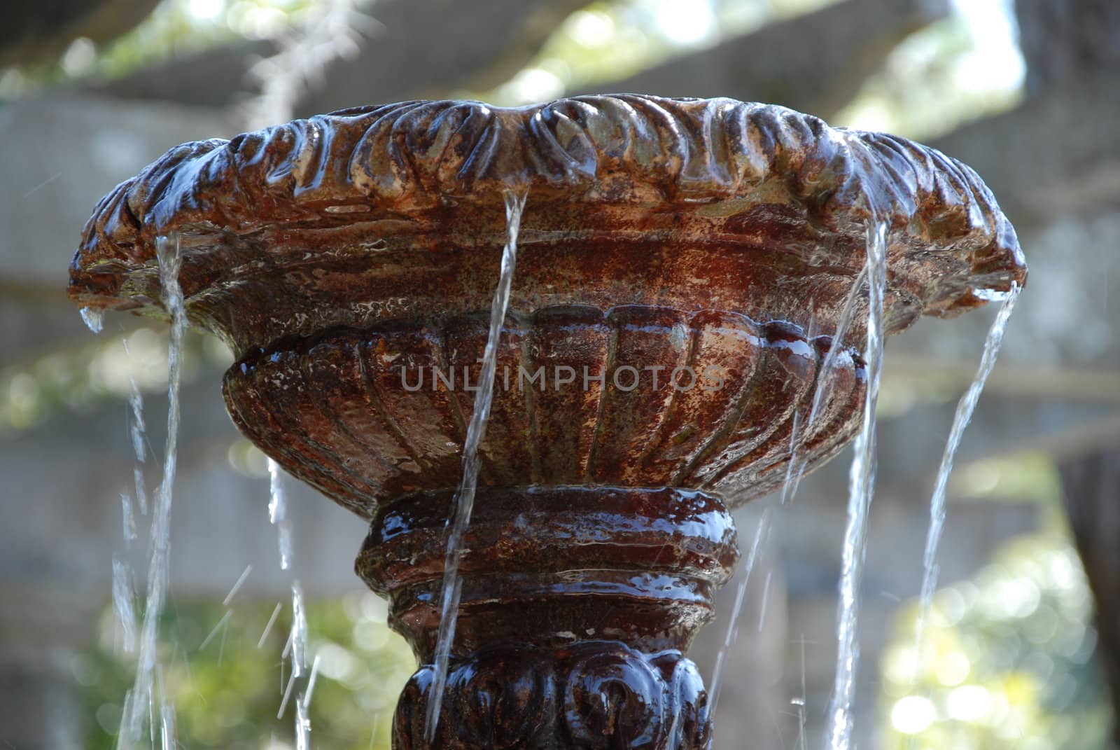 Water flowing over a statue fountain in a city park