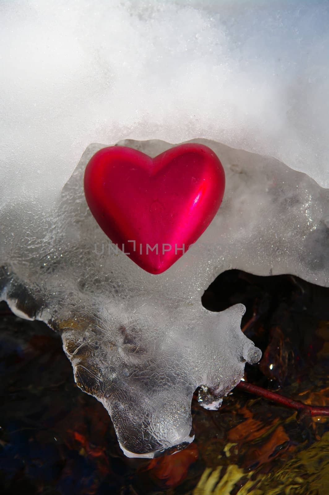 a red  heart on a real snowy icy surface