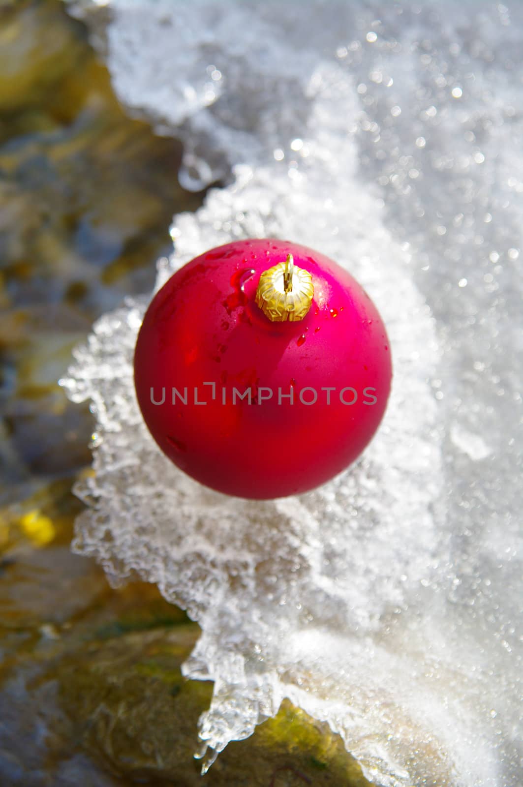 red bauble on a real snowy icy surface