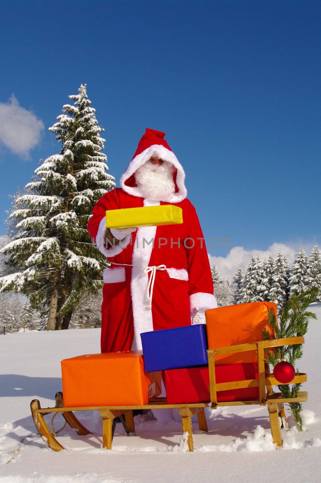 Santa Claus, Father Christmas with colorful presents on a sledge