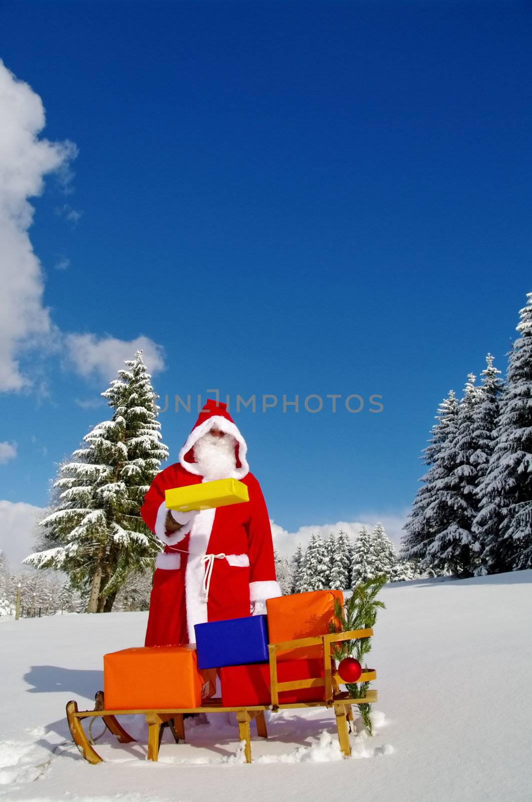 Santa Claus, Father Christmas with colorful presents on a sledge