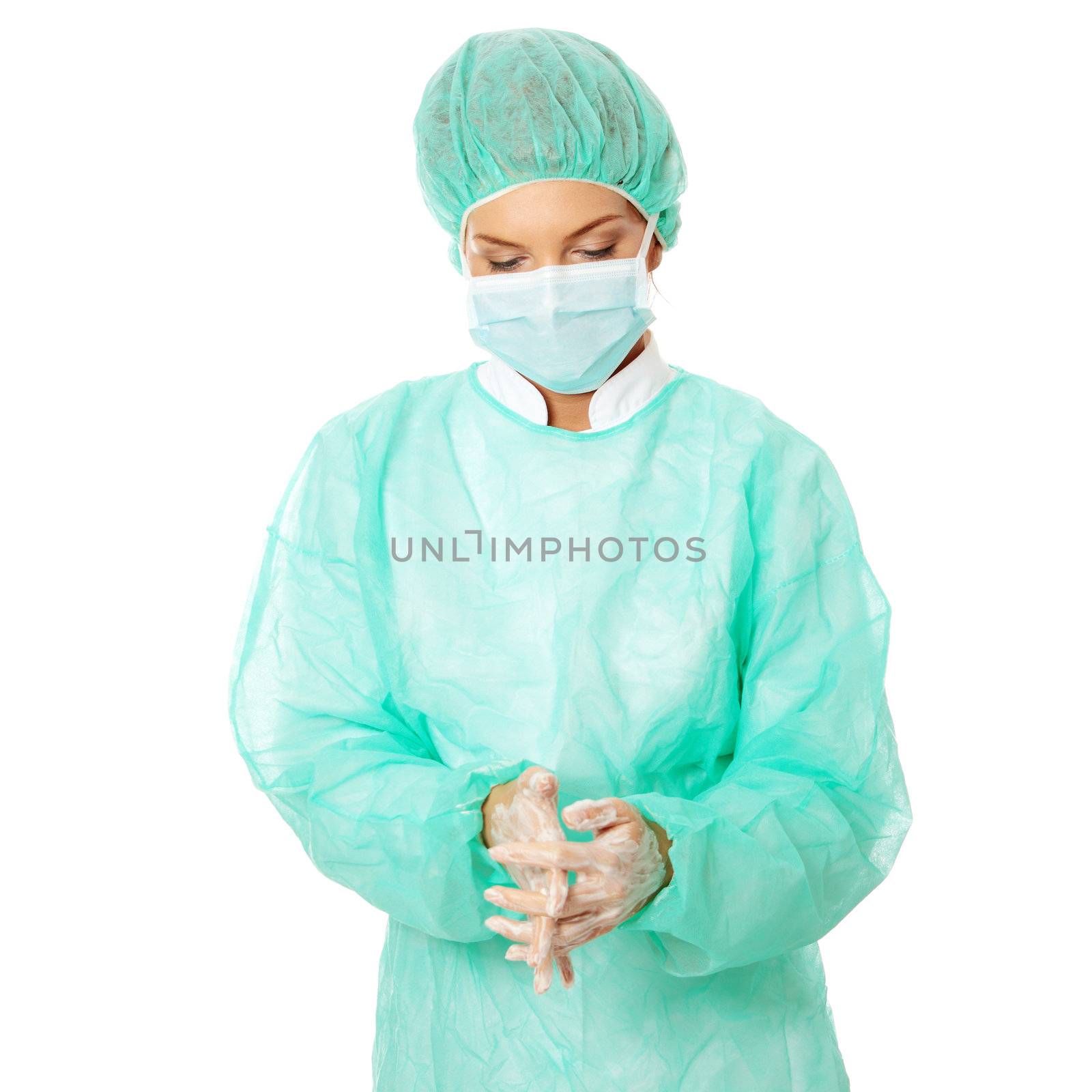 Female surgeon washing her hands, isolated on white