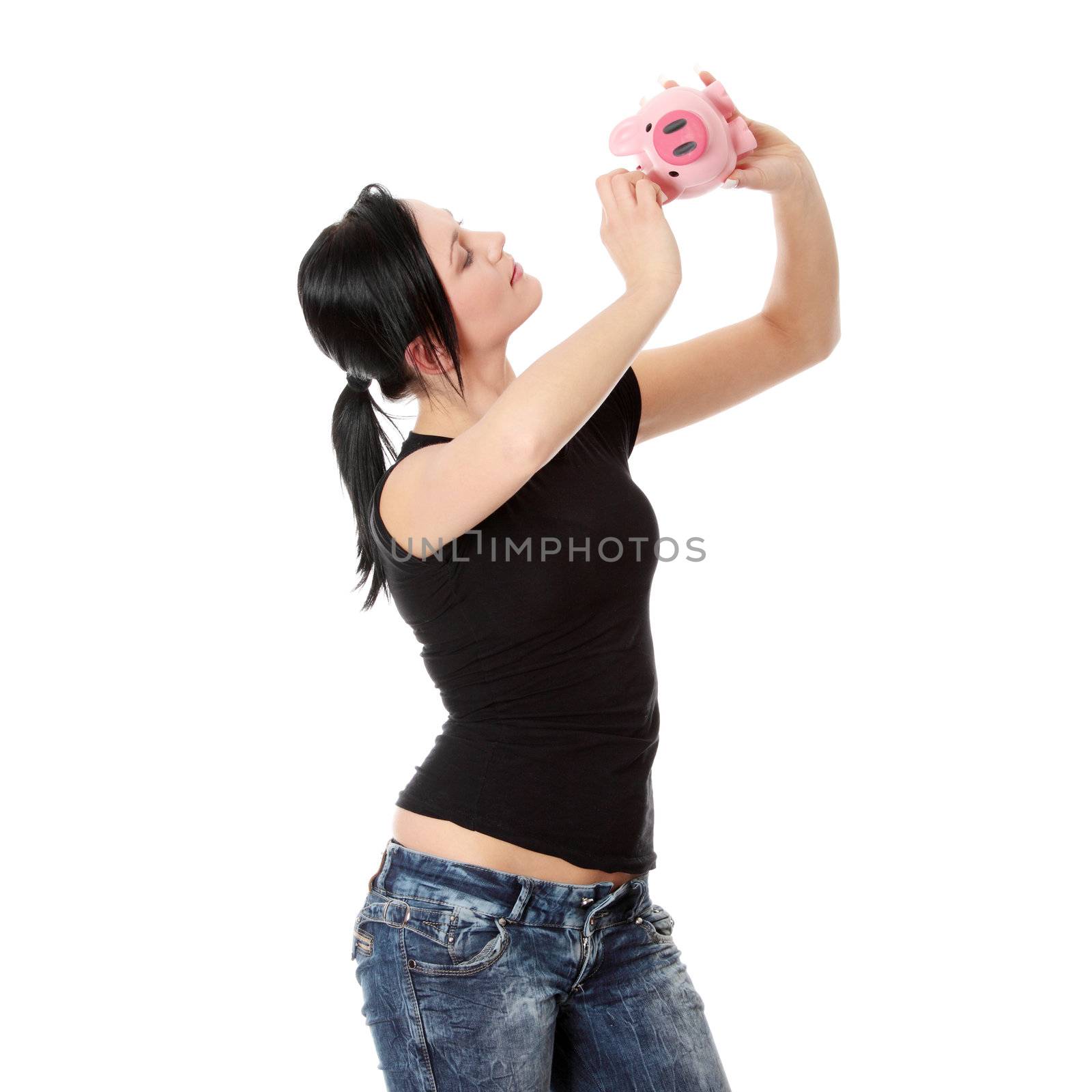 Savings concept - a woman with a piggy bank trying to get out some money - isolated over white 