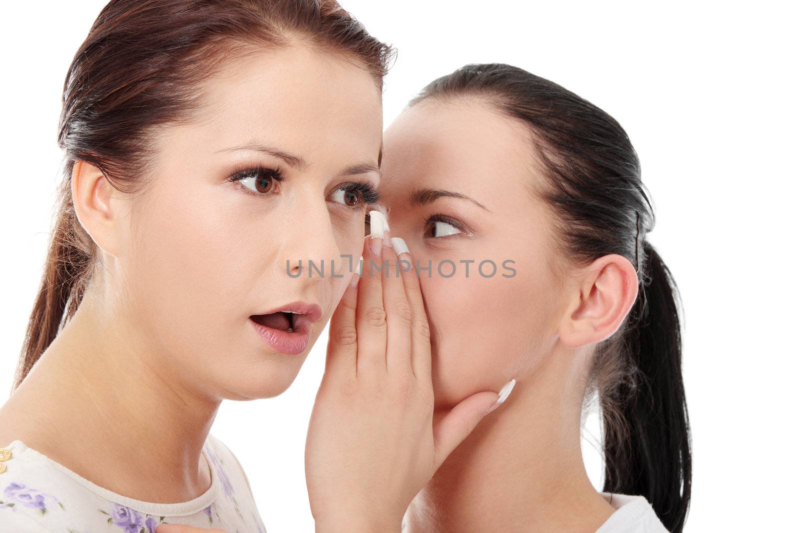 Two happy young girlfriends talking over white