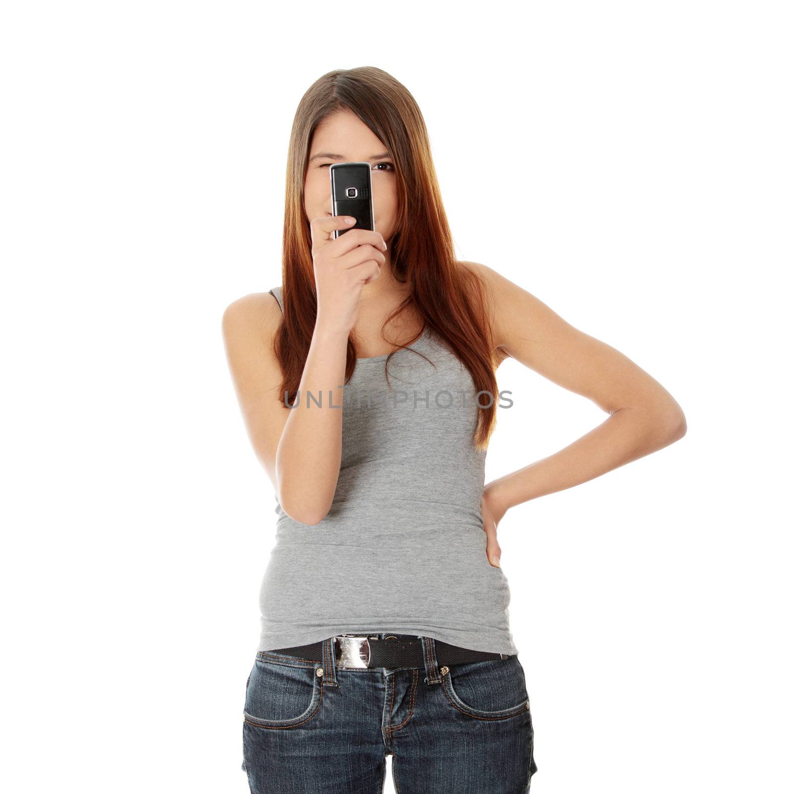 Teen girl using cell phone, isolated on white