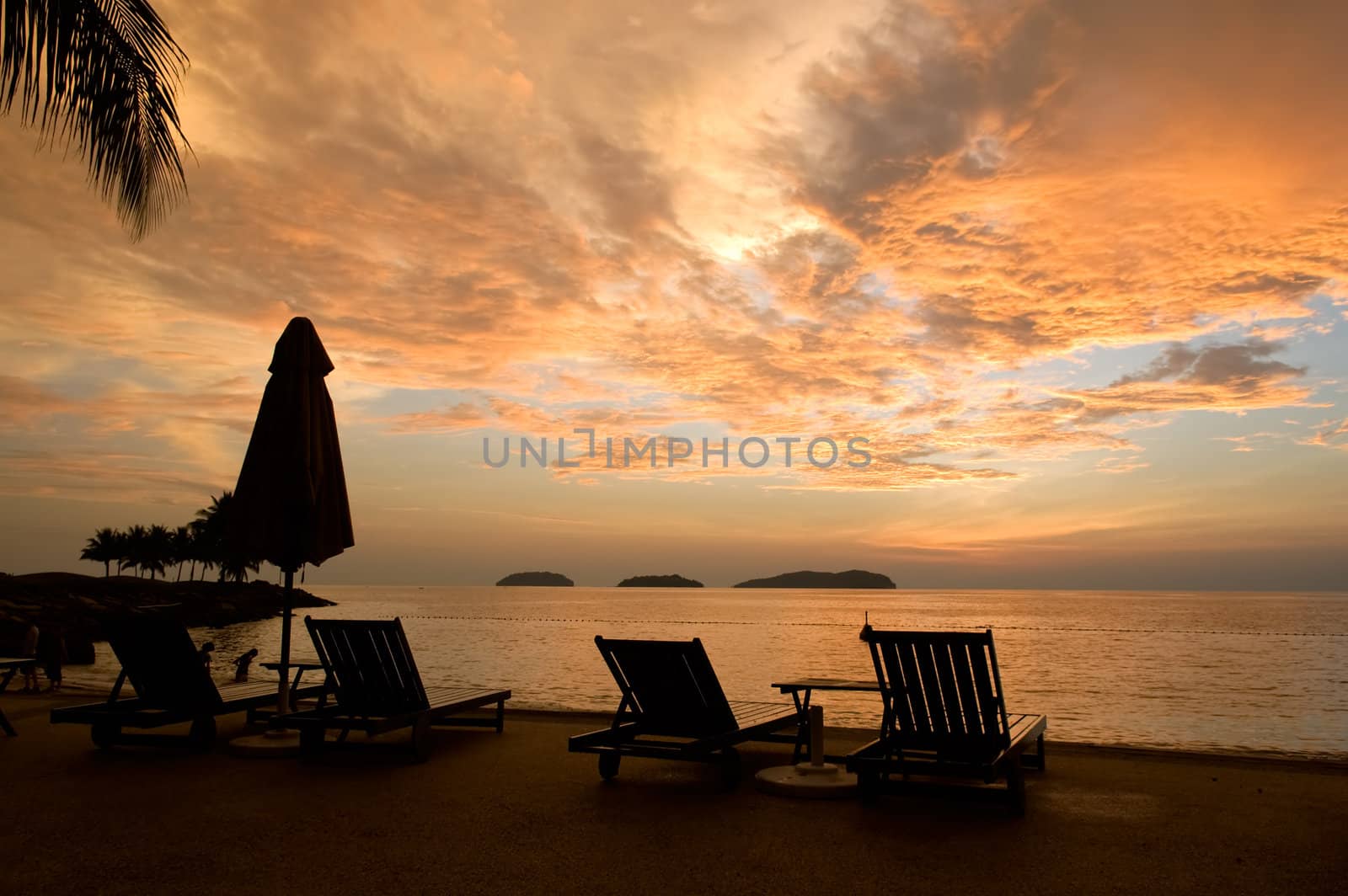 Silhouette of two relaxing seats at seashore