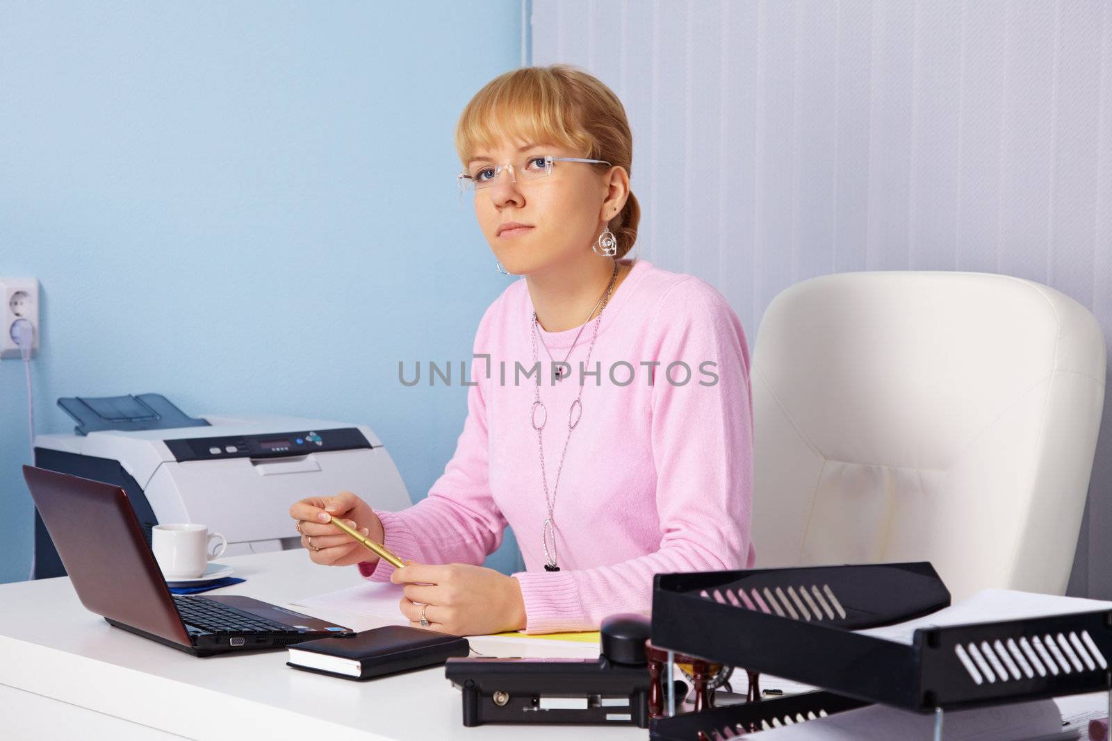 The young serious woman - the chief sits in an office