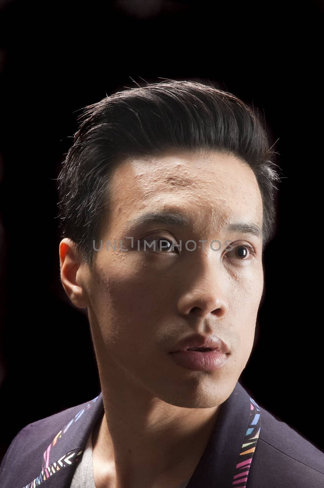 closeup of a young asian man on a black background