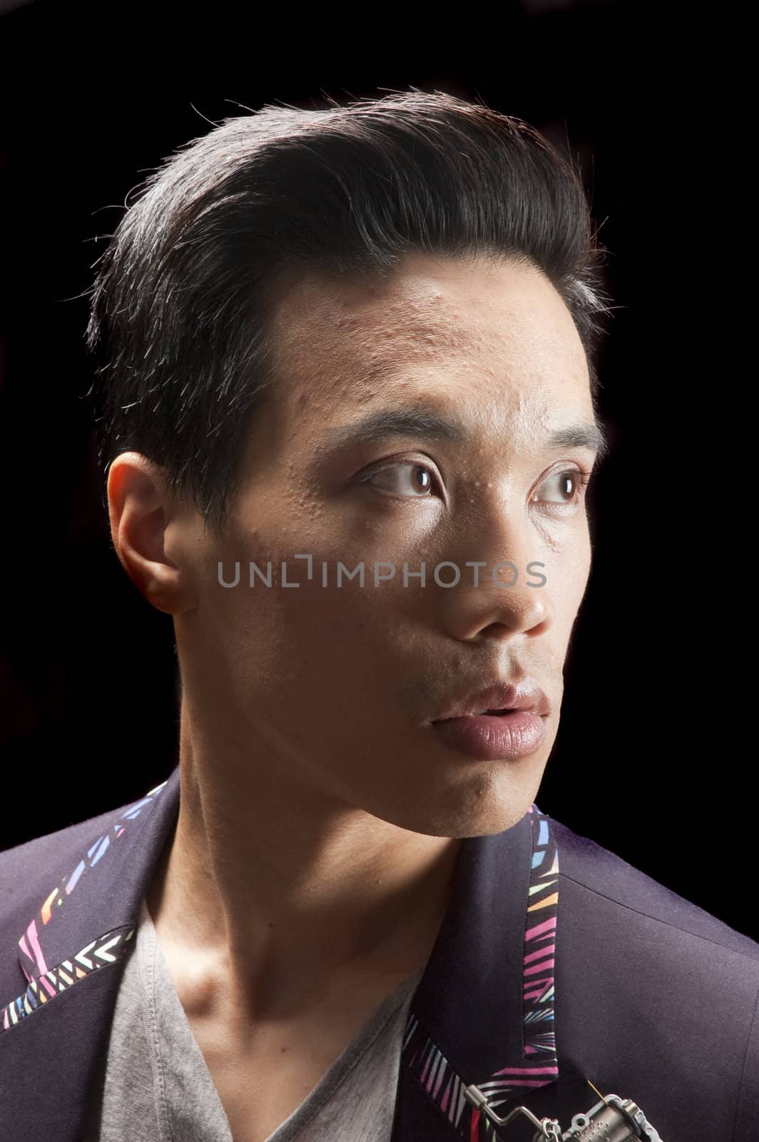 closeup of a young asian man on a black background