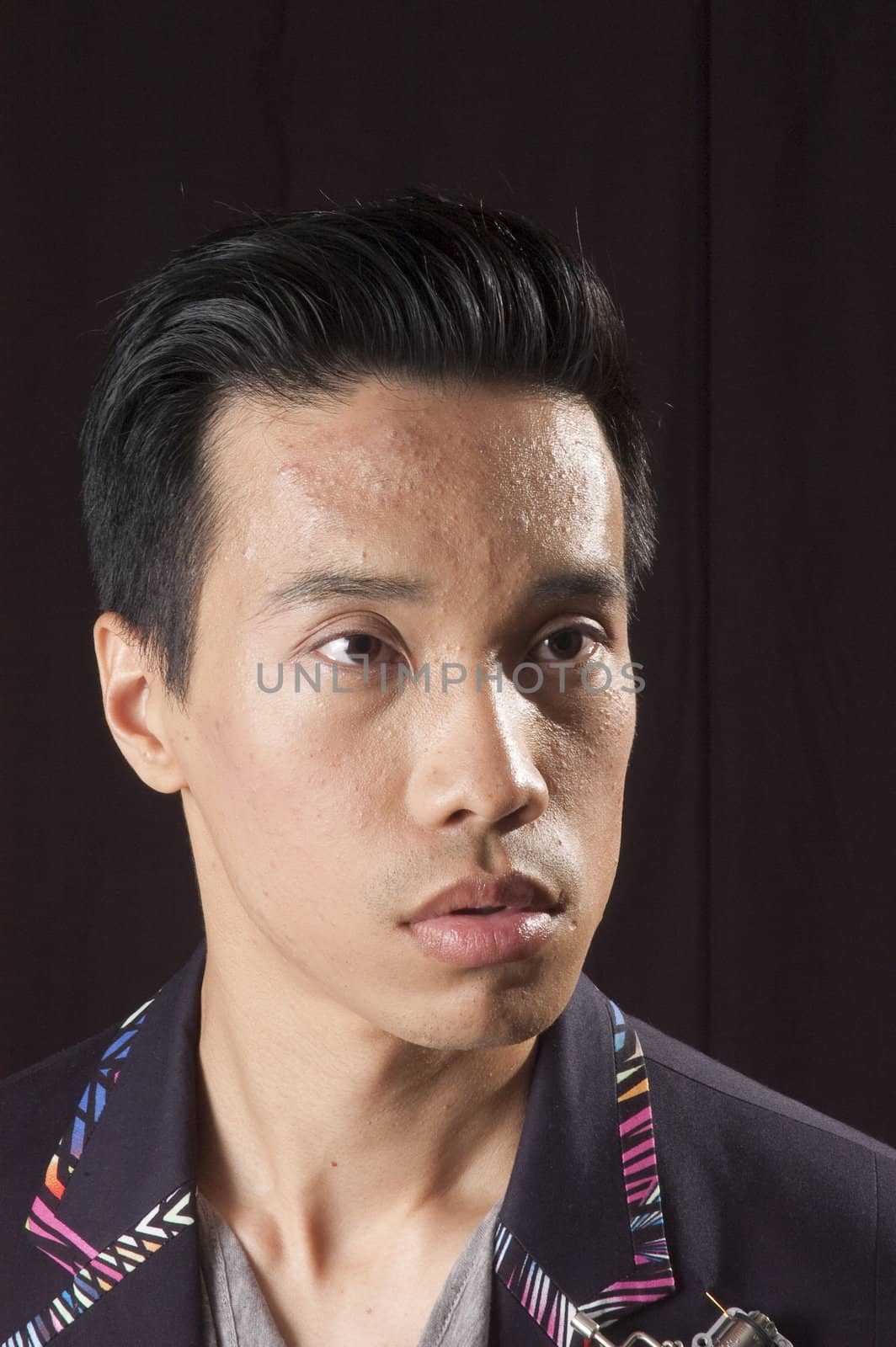 closeup of a young asian man on a black background