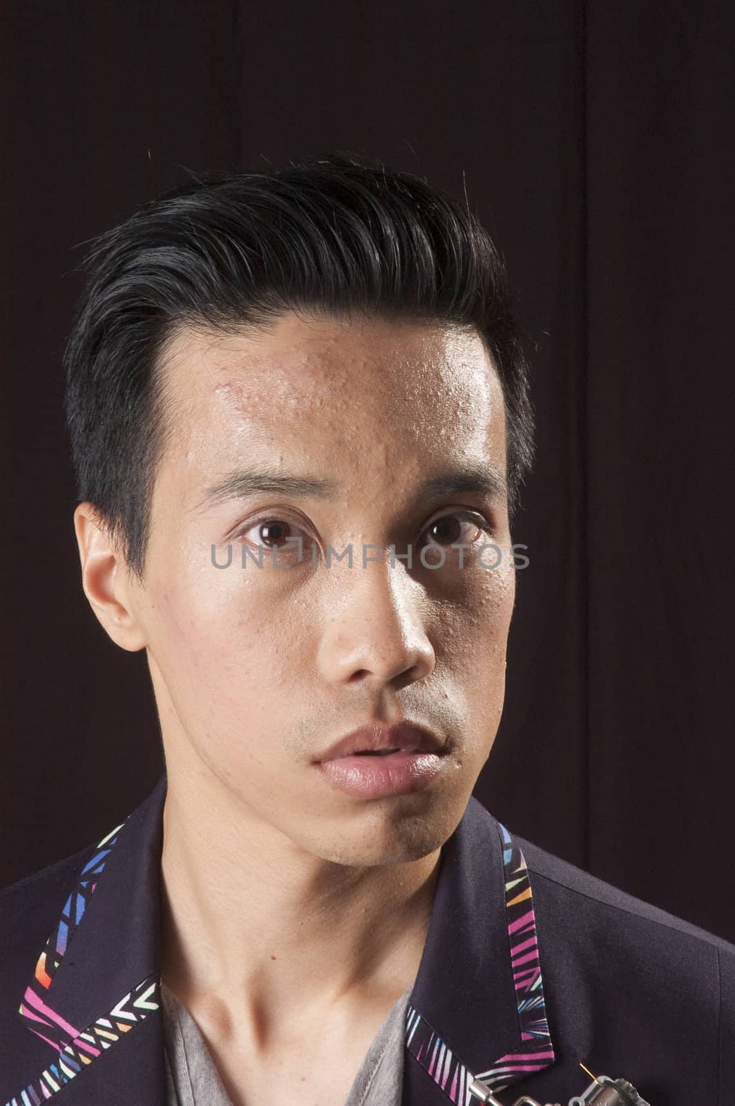 closeup of a young asian man on a black background