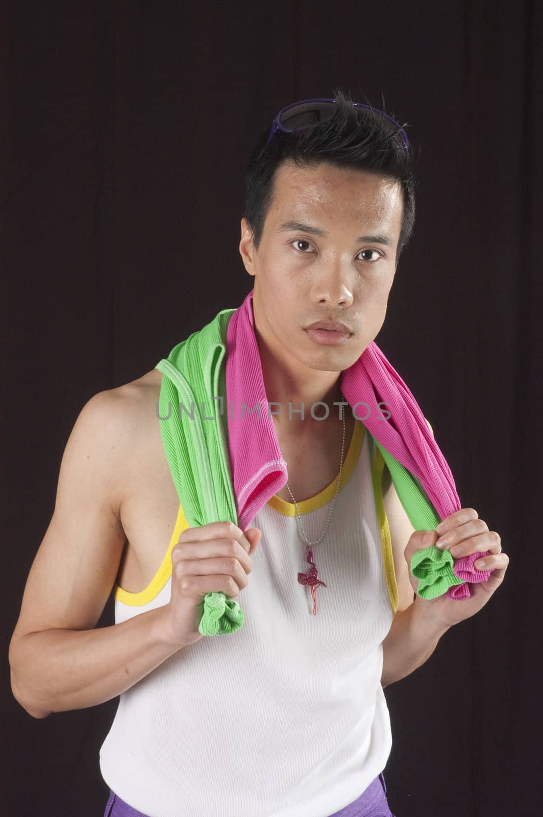 closeup of a young asian man on a black background with towel around neck