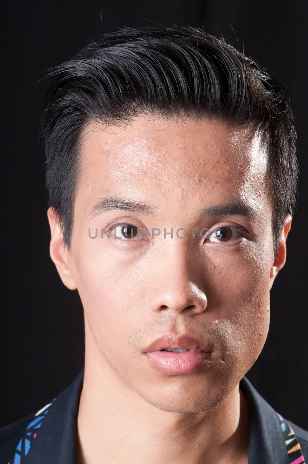Portrait of a young asian man over a black background