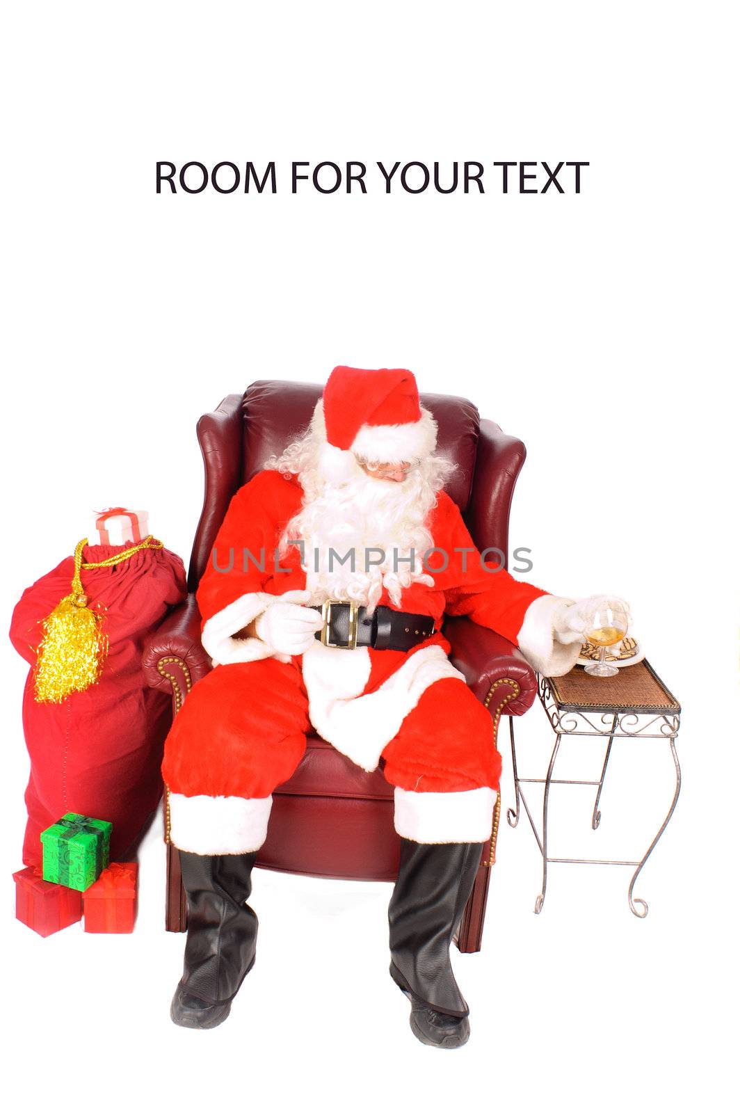 Santa sitting in an armchair drinking a glass of scoth or brandy with some cookies after a very bust night