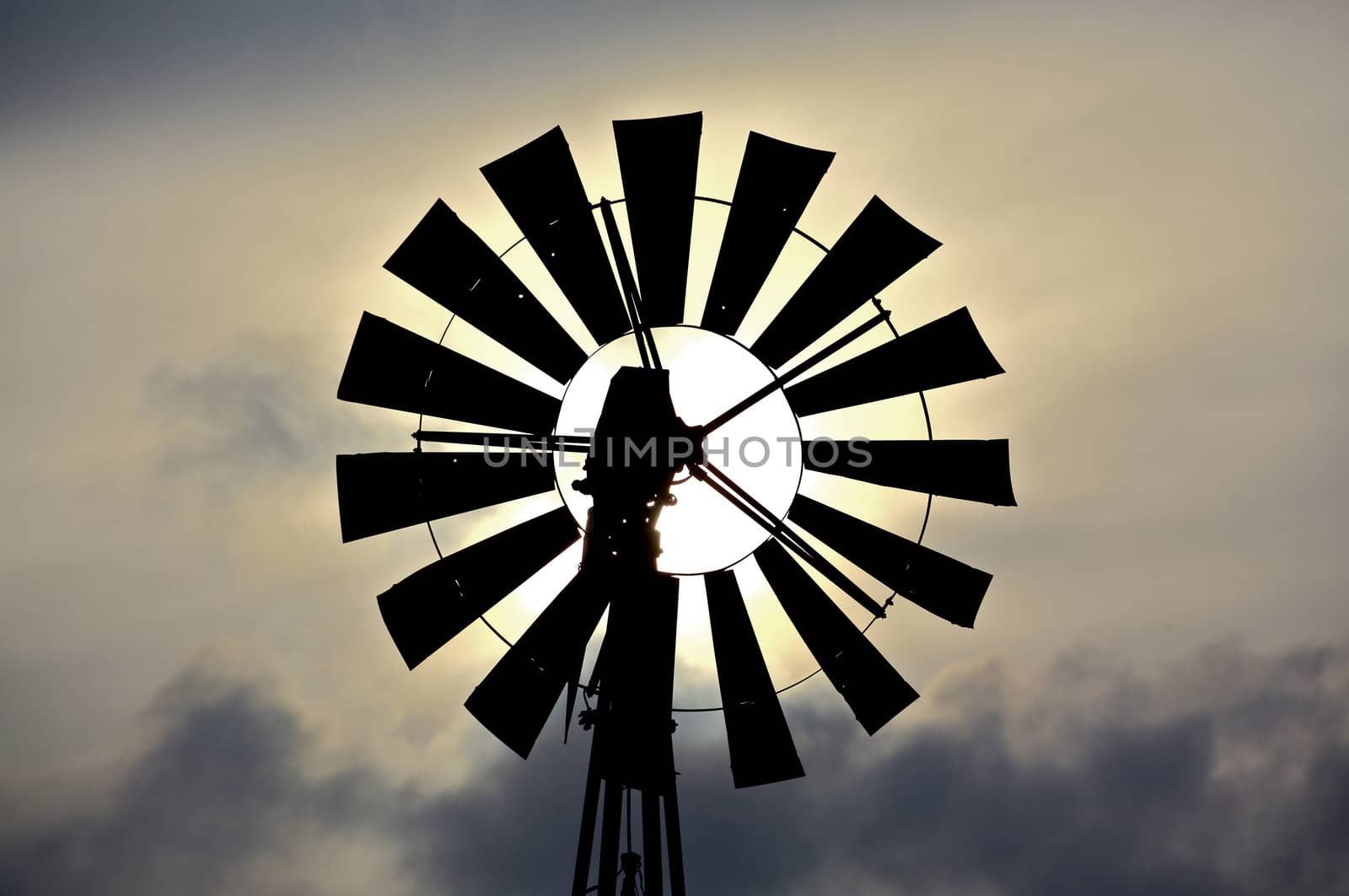 Silhouette of an old fashioned windmill against cloudy sky