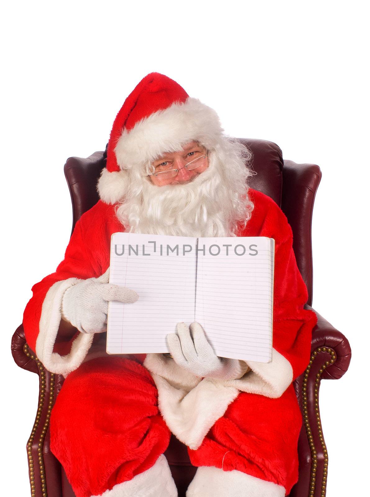 Humorus closeup of Santa Claus (that jolly old elf that  lives at the North Pole) reading and writing in the book of good children