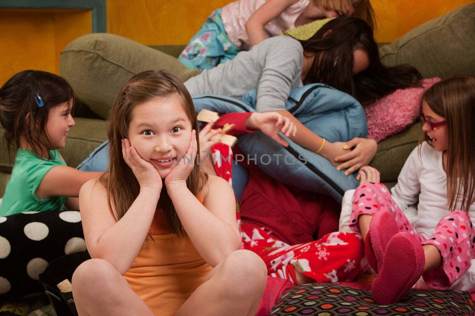 Girl overwhelmed with silly friends at a sleepover
