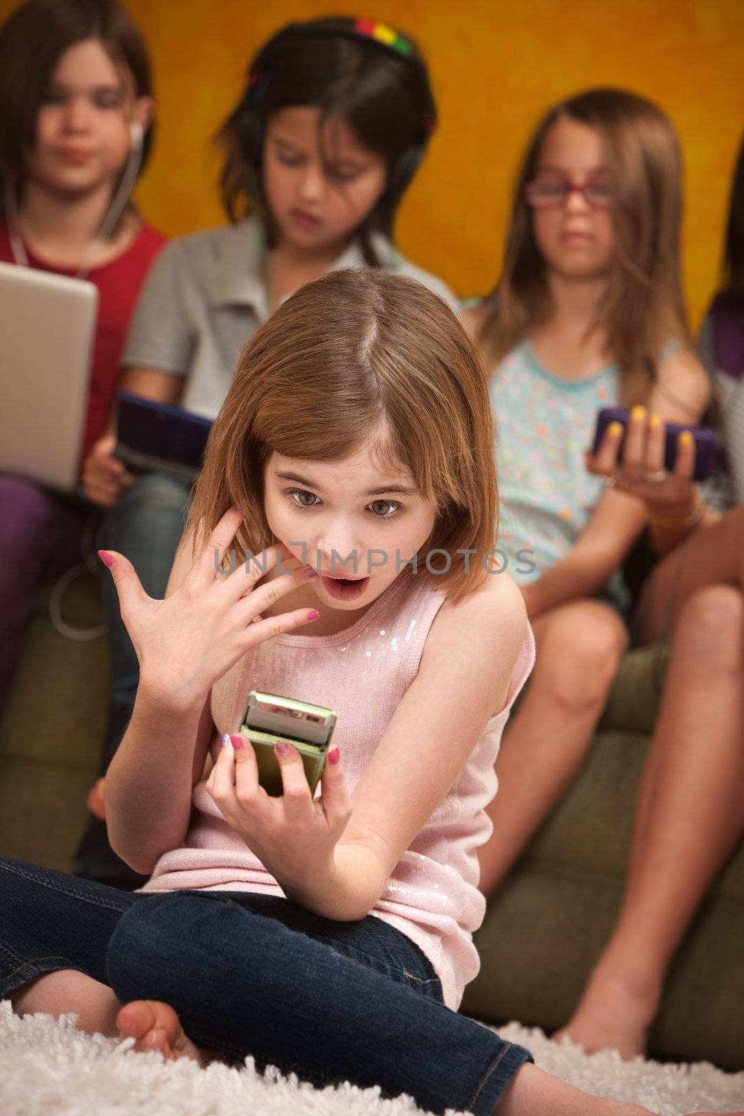 Surprised little Caucasian girl with a handheld device 