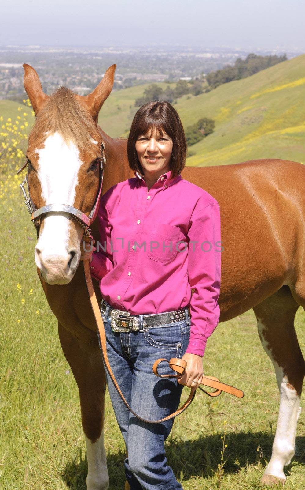 Attractive woman in the countryside with her horse