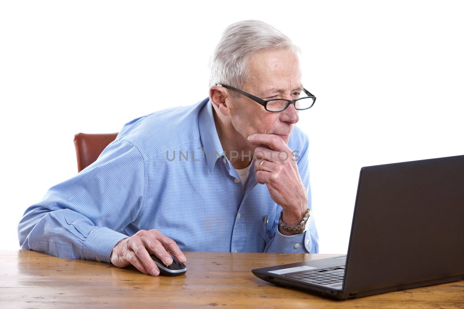 Senior man sitting behind his laptop computer