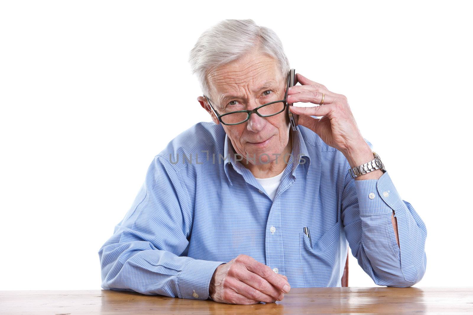 Senior man on the phone looking serioius on white background