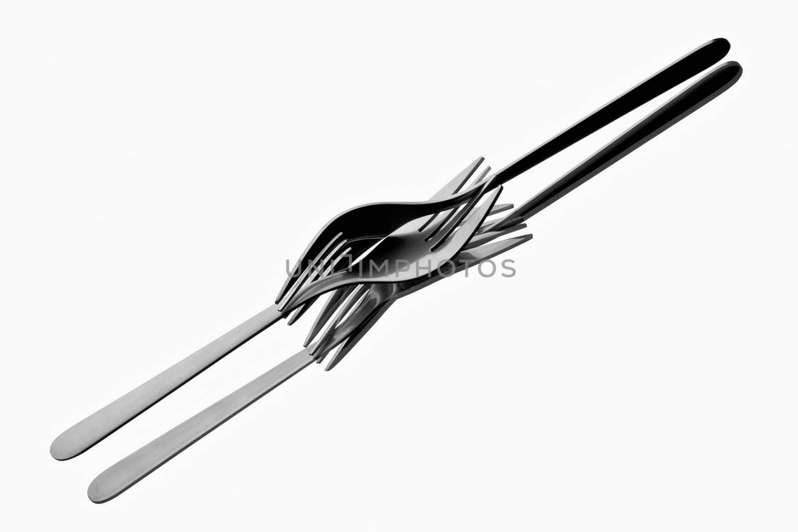Two forks tangled up on reflecting white background
