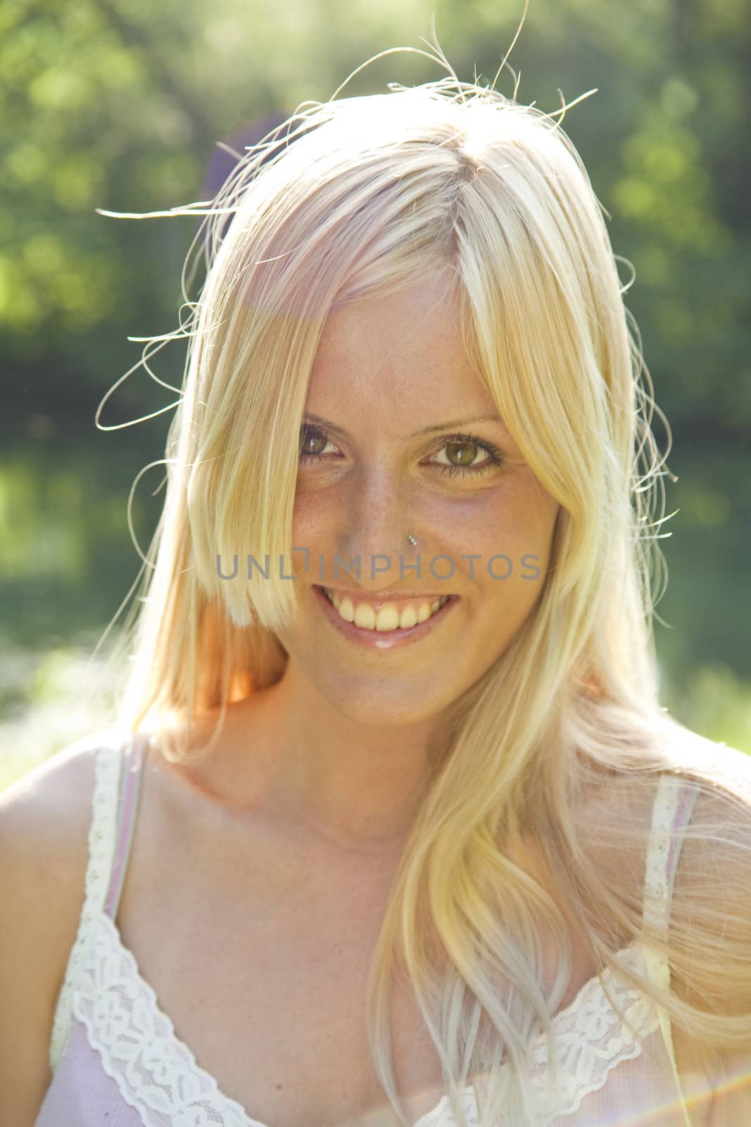 Beautiful blond woman smiling and resting in green environment