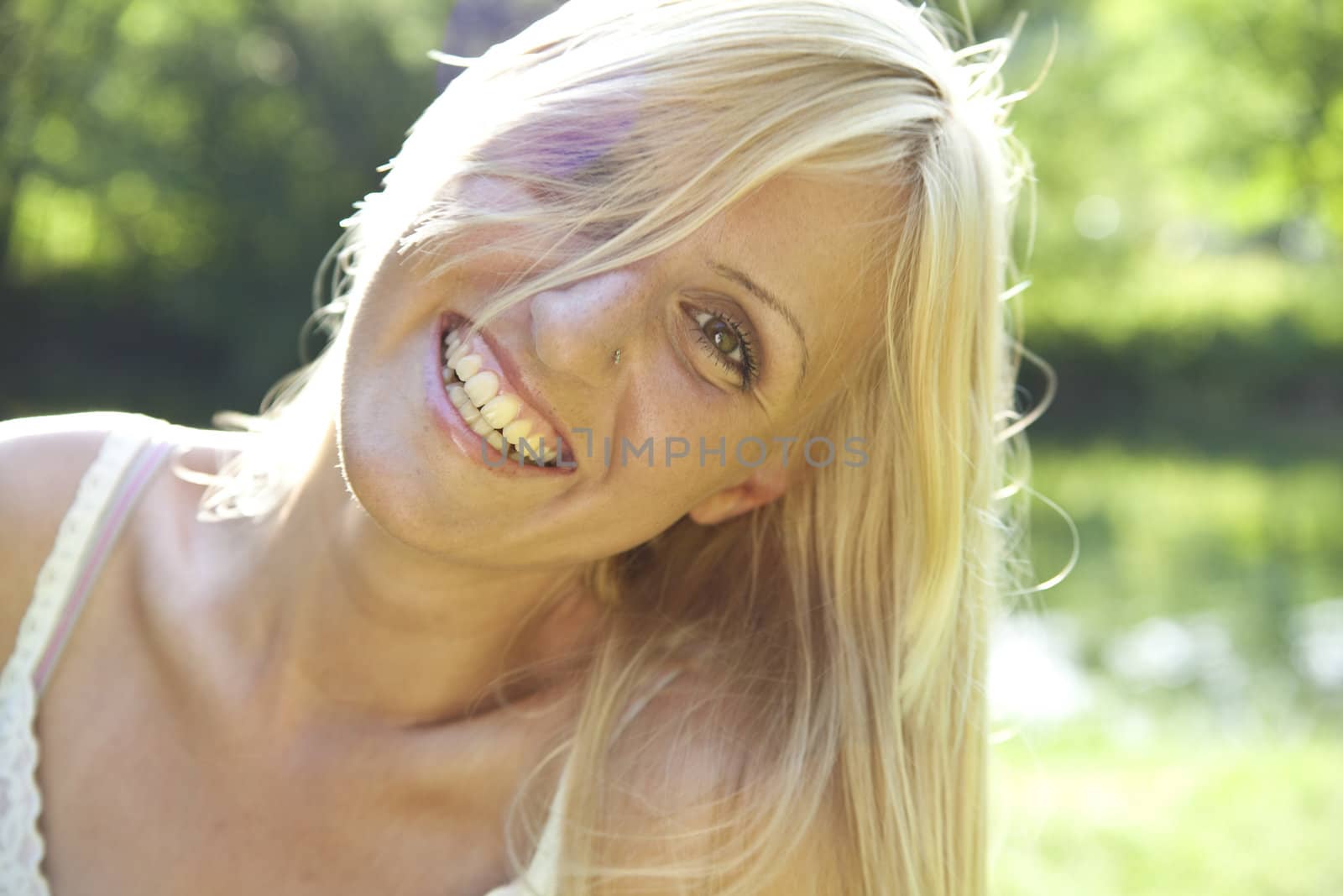 Smiling blond woman resting in green environment