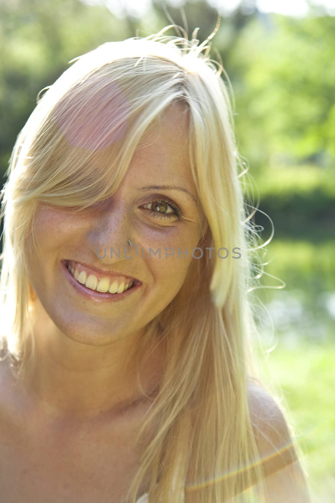 Smilingl blond woman resting in green environment