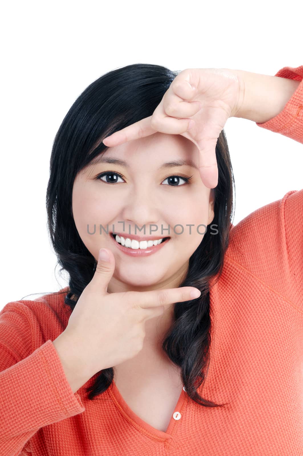 Portrait of an attractive young woman showing picture frame with her fingers, over  white background.