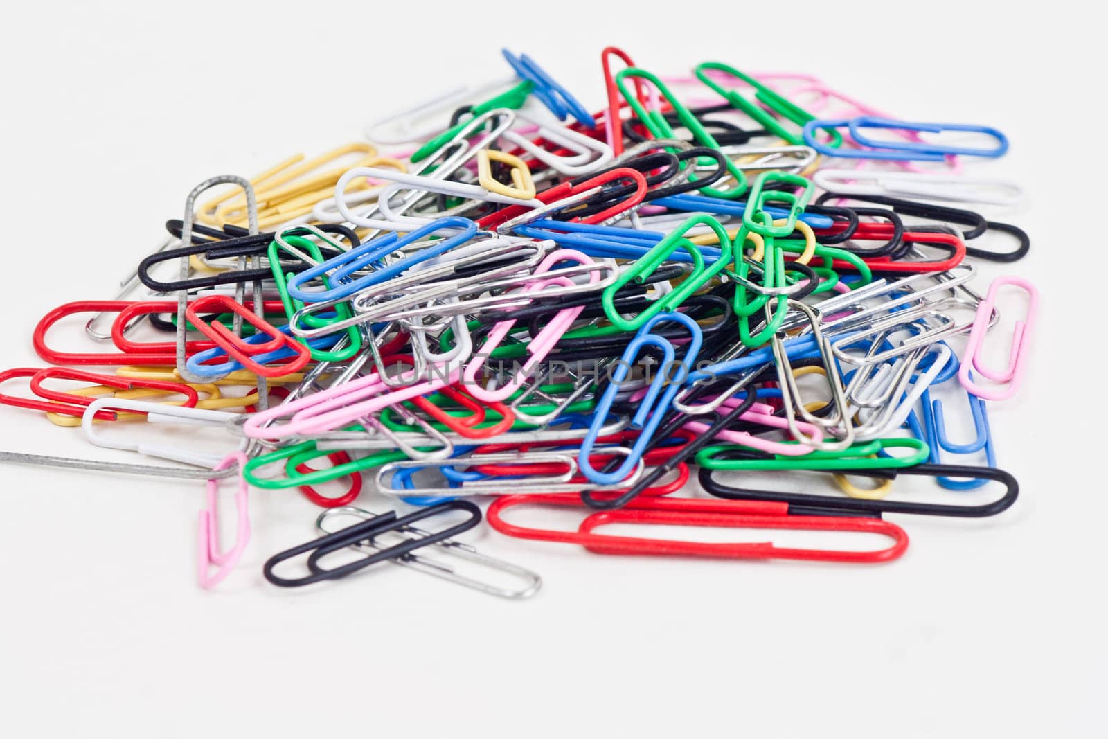 a plie of colored paper clips on a white background