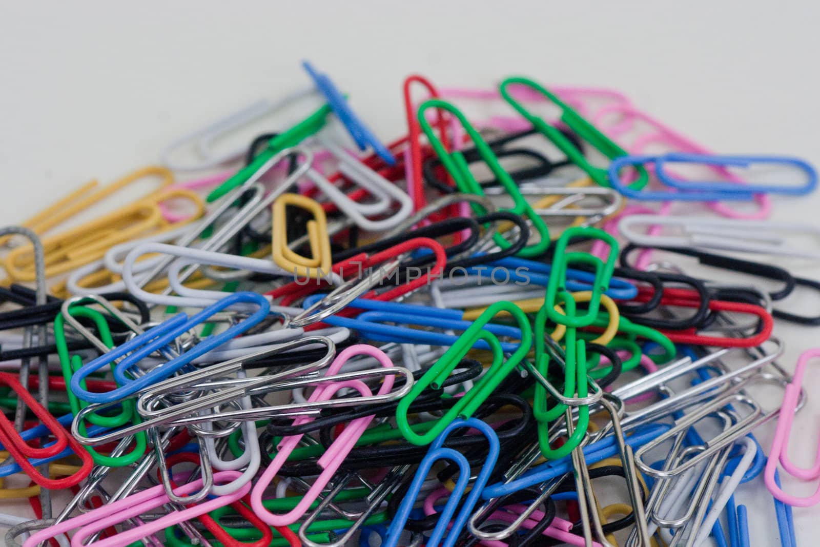 a plie of colored paper clips on a white background