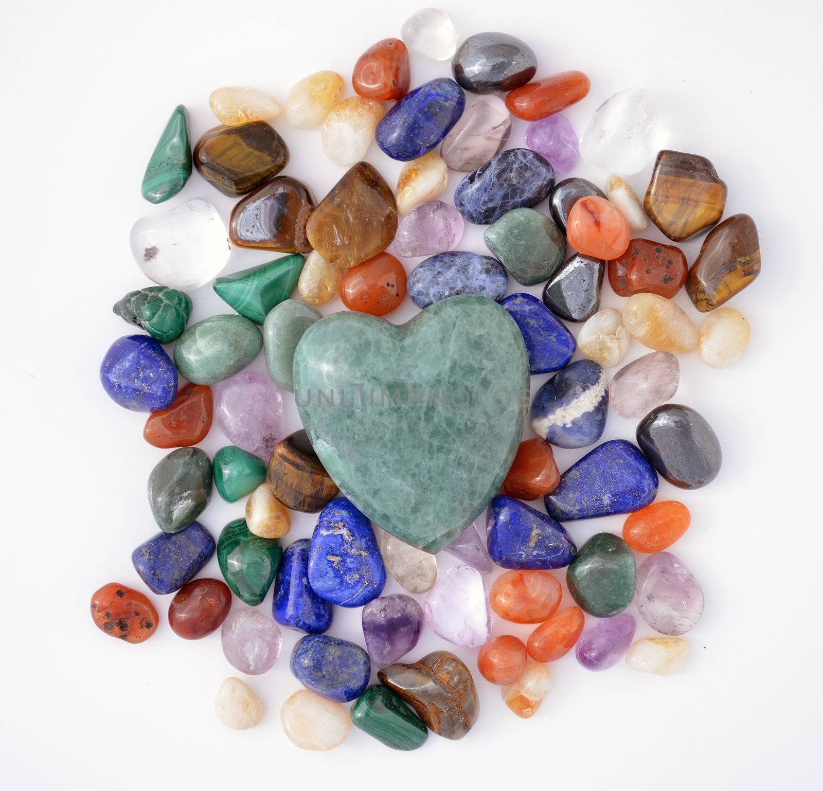 Green quartz heart among various semiprecious gems