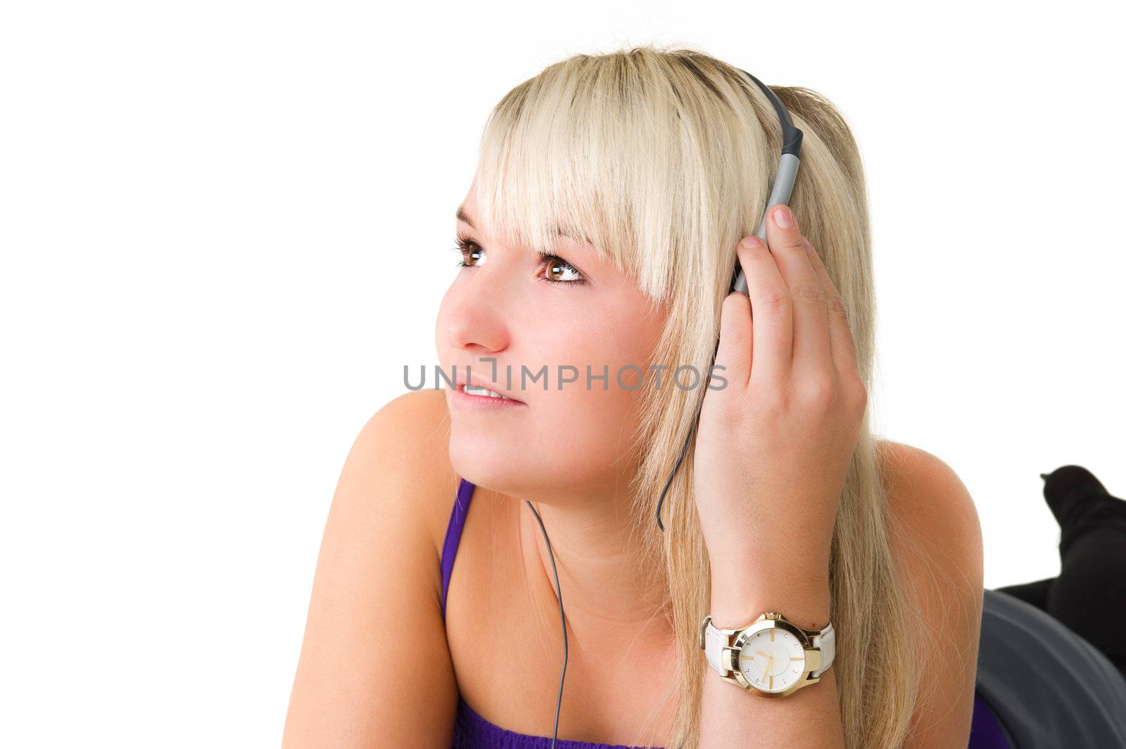 Young beautiful girl lying on the floor listening to music. Over white background