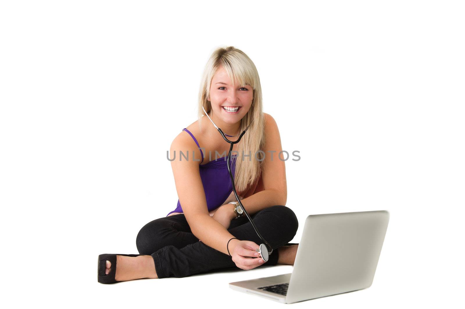 Young beautiful girl sitting on the floor checking here laptop. Over white background