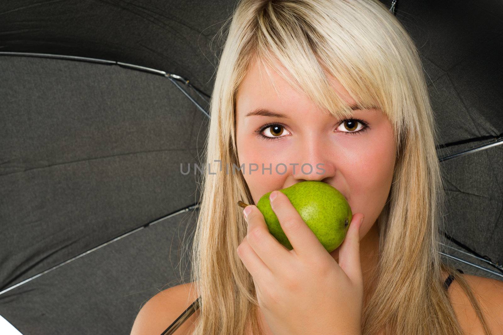 Beautyful girl bites an pear under a black umbrella. Over white backgrund
