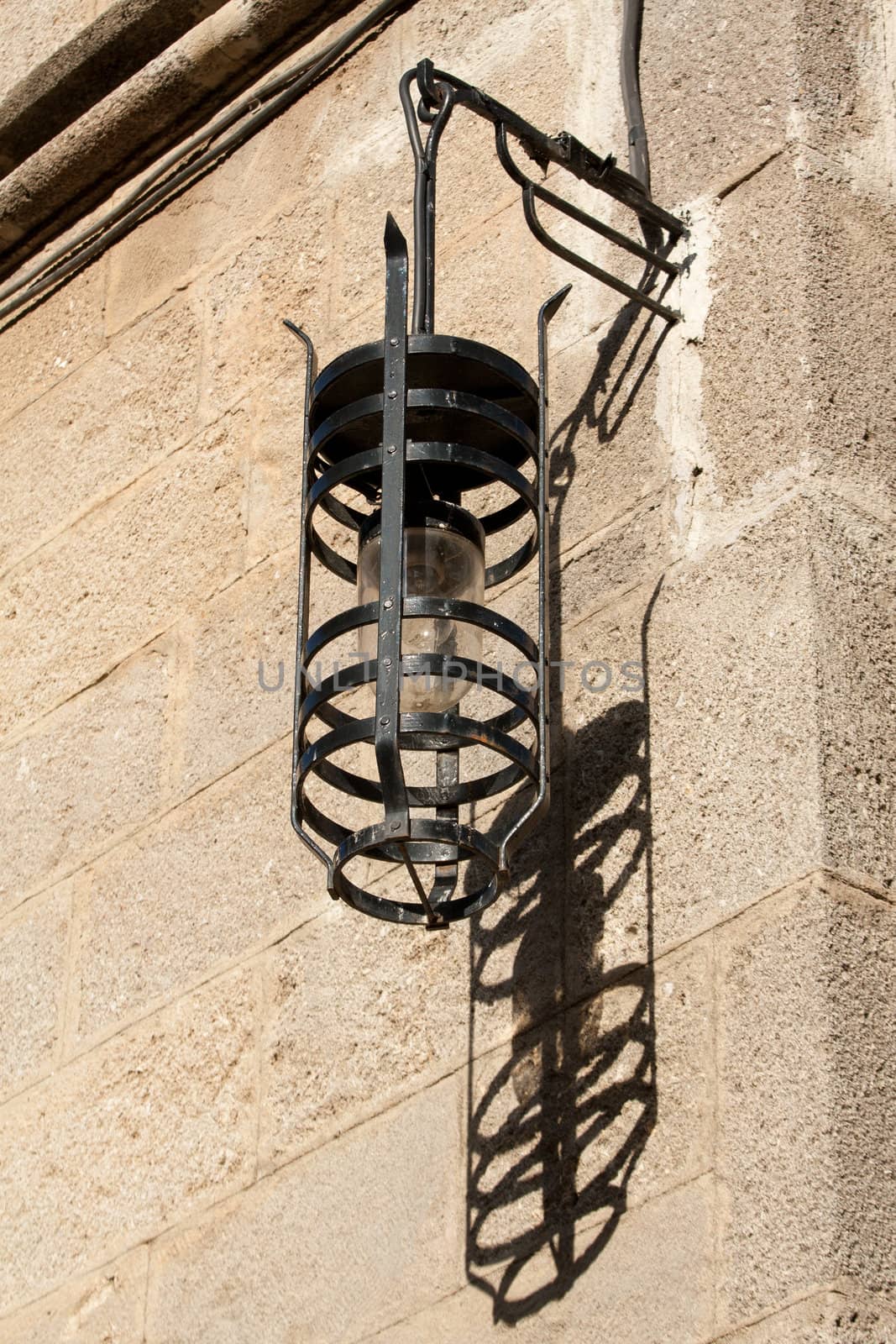 Old street lamp and its shadow in Ippoton (Street of the Knights) in Old Town Rhodes (Greece), a World Heritage Site.