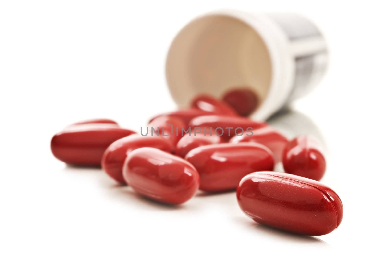 Red pills an pill bottle on white background by tish1