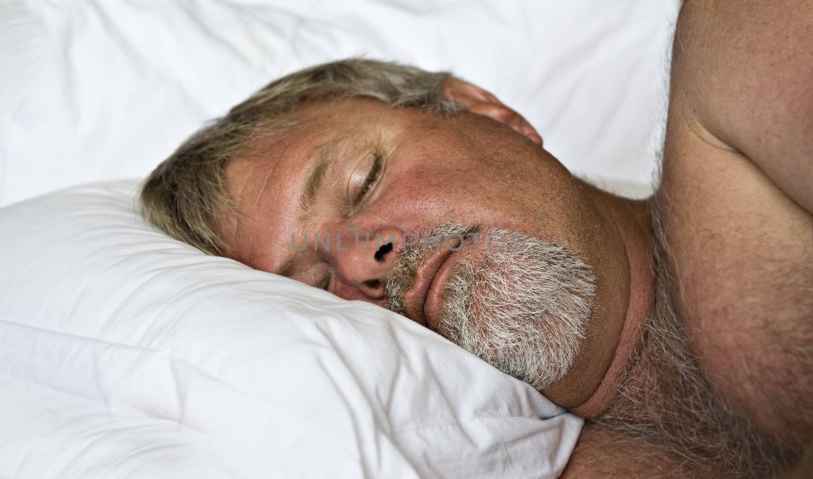 Senior man sleeping peacefully - intentional low light and shallow depth of field