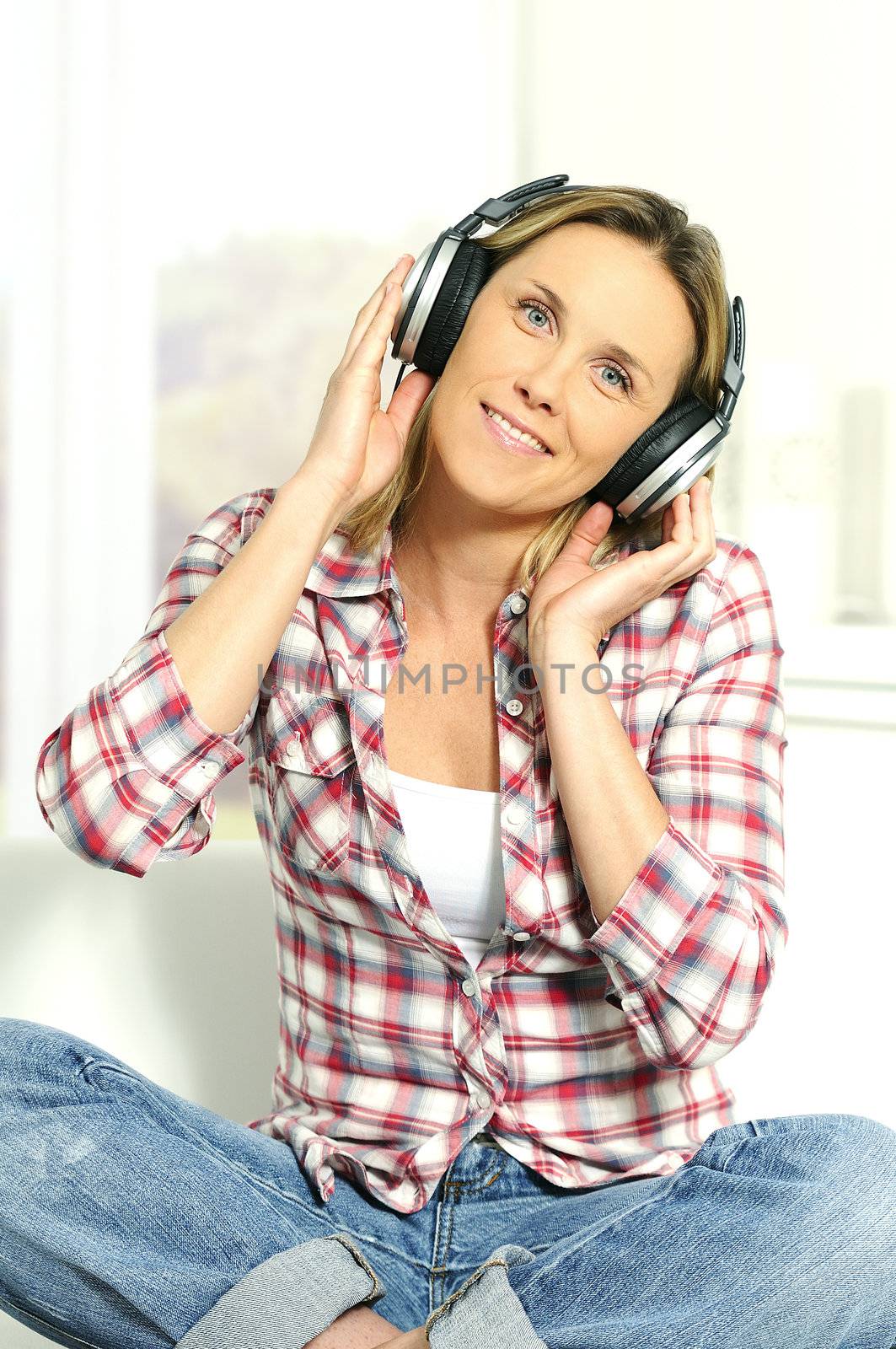 blond woman relaxing at home, listening music