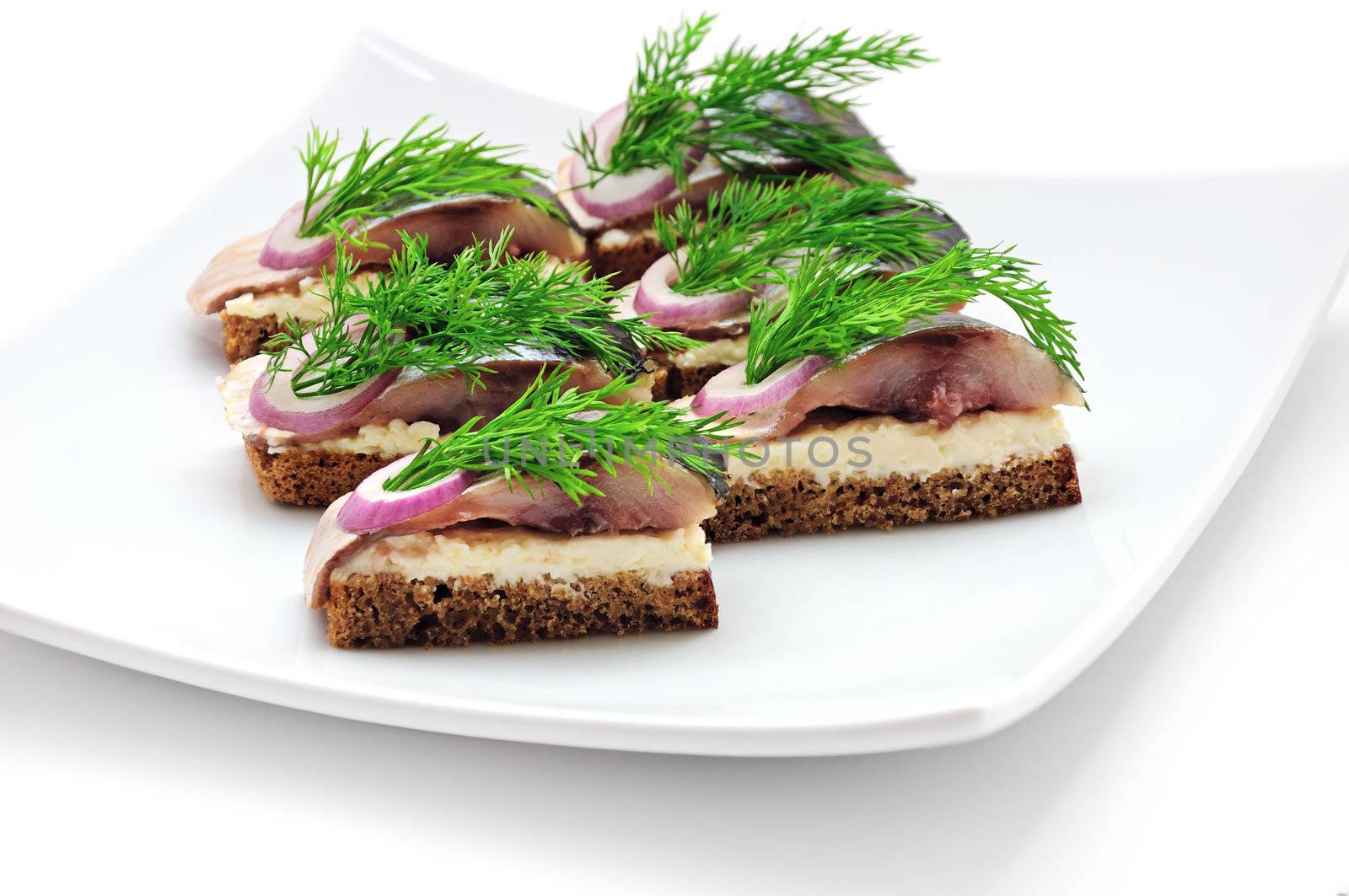 Sandwiches of rye bread with herring, onions and herbs.