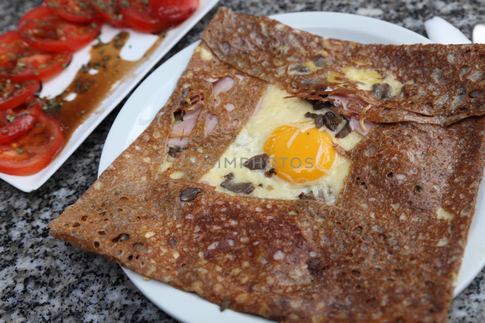 Image of a buckwheat flour pancake containing egg,ham,mushroom and cheese.Such food is specific for the entire France mostly in Normandy and Brittany.